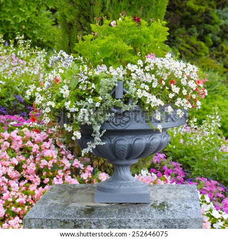 flower bed and stone vase with flowers