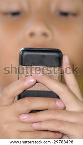 A boy concentrate plays games on mobile phone