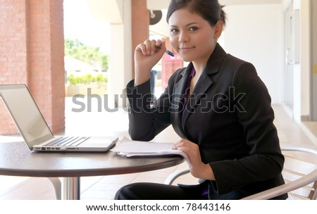 Smiles of young Asian businesswoman working outside.
