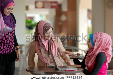 Pretty Asian Muslim college girls meeting friends at coffee shop