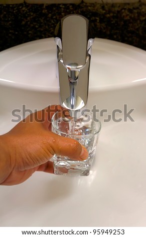 filling a glass of fresh water from water tap