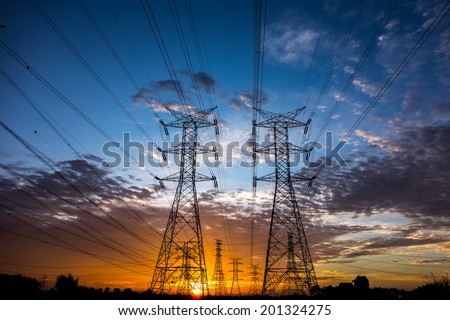 Electricity pylons and cable lines during sunset. Horizontal format