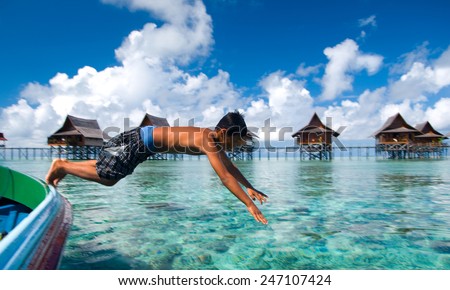 SEMPORNA, MALAYSIA - JULY 4 : Unidentified Sea Bajau\'s kid jump from a boat July on 4, 2009 in Sabah, Malaysia. Children here do not attend school for lack of means and resources.