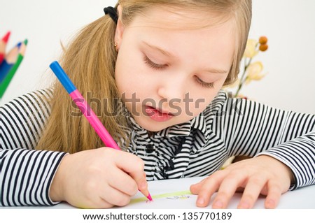 Closeup	portrait of girl drawing with colorful pencils