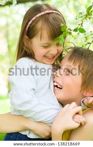portrait of a child, the love of brother and sister in his arms outdoors