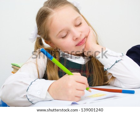 Closeup portrait of a schoolgirl drawing with colorful pencils