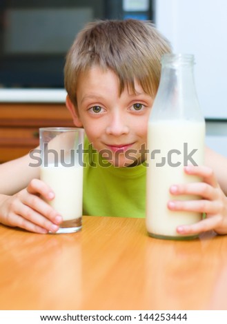 happy little boy loves milk indoors