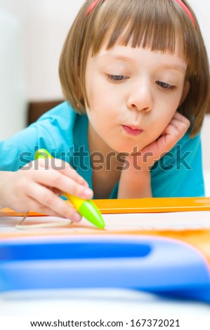 Little girl writing at magnetic drawing board