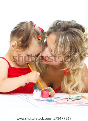 Child with mother painting indoors