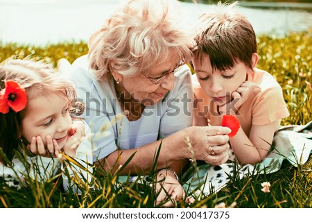 Closeup summer portrait of happy grandmother with grandchildren outdoors