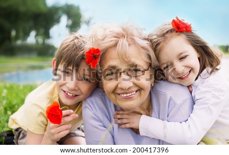 Closeup summer portrait of happy grandmother with grandchildren outdoors