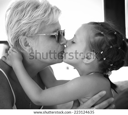 grandmother and her cute little granddaughter giving each other a loving
