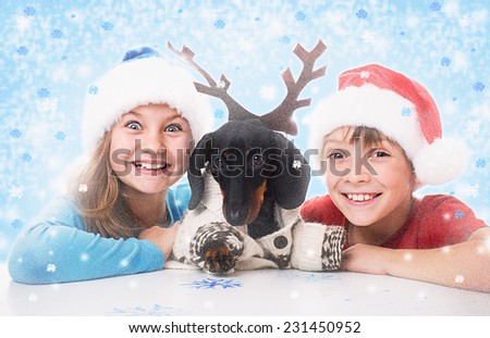 children plays with dachshund in Christmas masks of Santa, Snow Maiden and deer