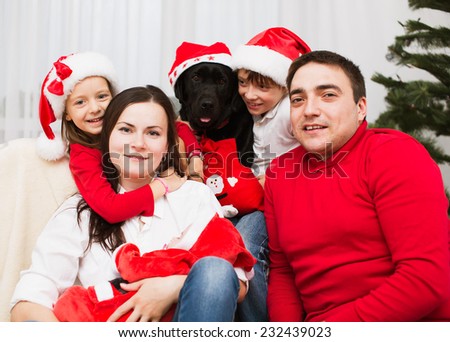 Big Family. Parents with three children and dog labrador in santa hats