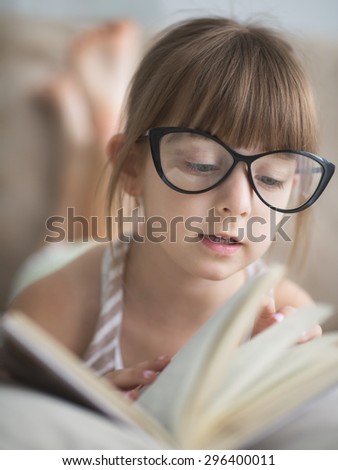 cute little girl is reading book