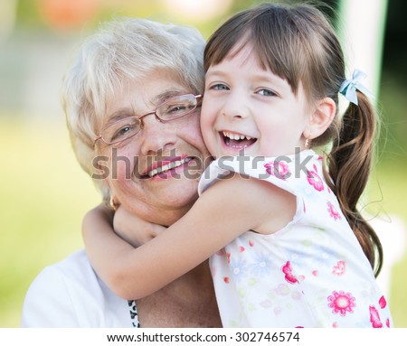 Closeup summer portrait of happy grandmother with granddaughter outdoors