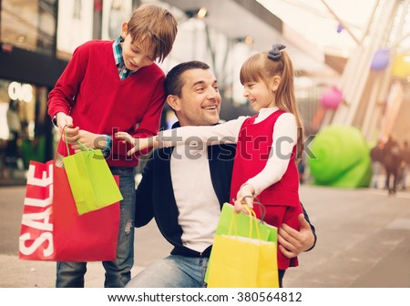 Happy father with children have a successful day of shopping