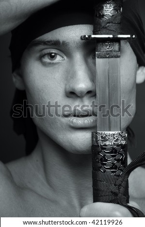 Male portrait with a half covered face with a sword