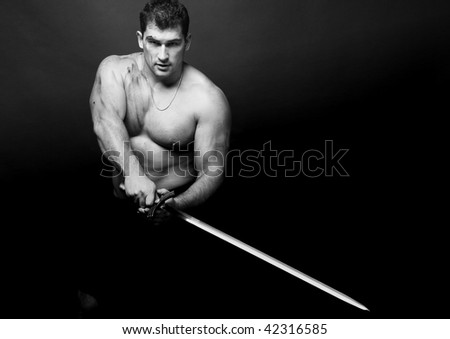 Muscled male model in studio with a sword