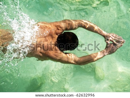 Male model swimming in clear water