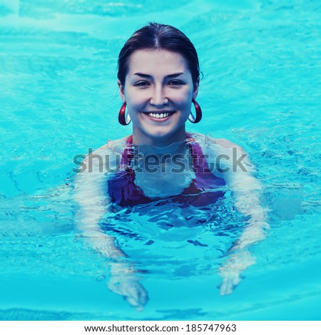 Young beautiful woman in swimming pool with retro filter effect. Closeup.