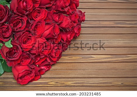 Colorful flower bouquet from red roses on wooden background. Closeup.