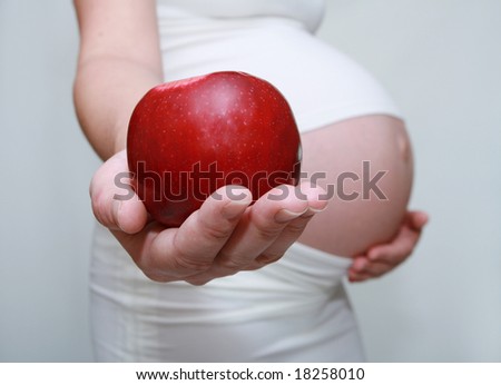 Pregnant woman holding apple. Nine month. Third trimester.