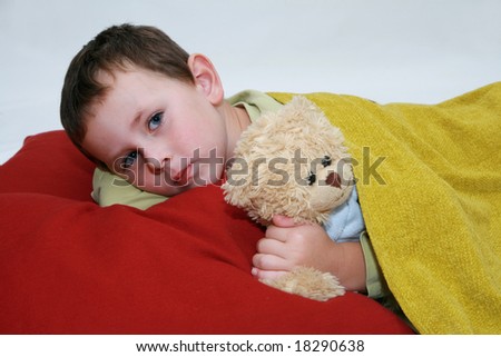 Boy in bed. Five years old boy lying in bed with teddy bear.