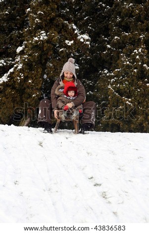 Baby and mom sledding in cold winter day