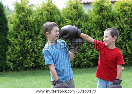 Child fighting with boxing gloves. Sibling, two boys boxing.