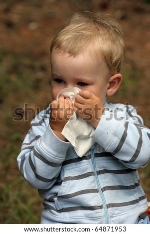 Baby boy blowing nose. Child with tissue. catarrh or allergy