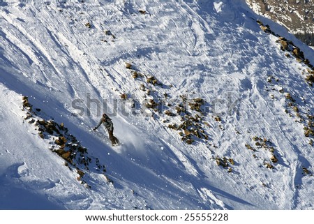 A female snowboarder makes a turn down a steep run.