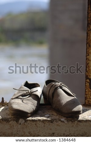 Pair of old shoes resting on a concrete ledge