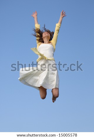 Jumping for joy against blue sky