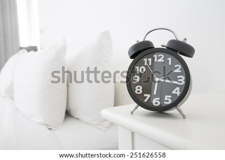 Black alarm clock and bed