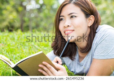Asian woman with a book in the garden