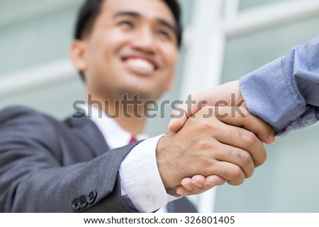 Asian businessman making handshake with smiling face