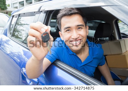 Asian man driver smiling and showing car key