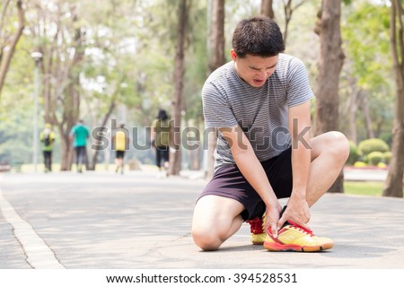 Sports injury. Man with pain in ankle while jogging