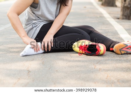 Sports injury. Woman with pain in ankle while jogging