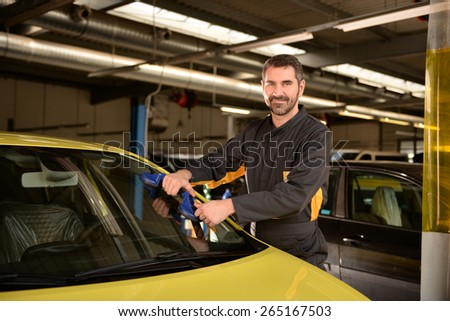 Car mechanic checking car at auto repair shop service station, window repair