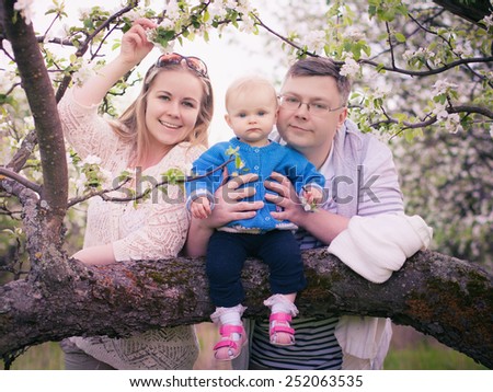 Family for a walk in the lush garden or the park in spring sunny day