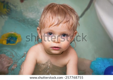 Little girl smiling and playing in the bathtub with her parents. cooperative games. Fathers and Sons