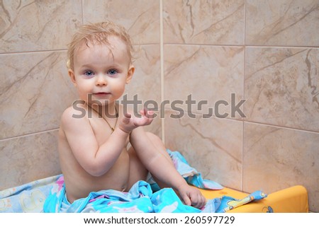 Little girl smiling . Funny little baby girl .Girl sitting in the bathroom after a bath