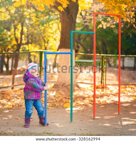 Happy little girl throws the autumn leaves in the air. happy child having fun on the playground
