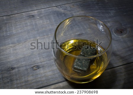 Glass of Bourbon with Whisky Stones on a Vintage Wood Farm Table