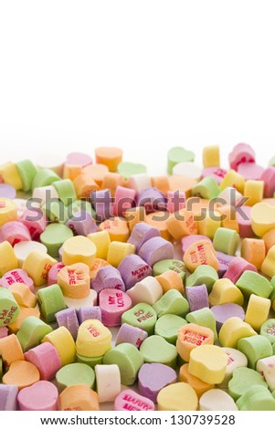 Pile of conversation heart candies on white background.