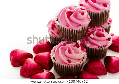 Stack of pink cupcakes with engagement ring on top.
