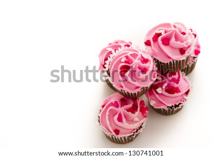 Stack of pink cupcakes with engagement ring on top.