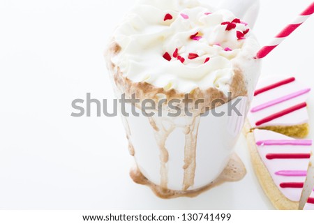 Messy hot chocolate with white and red straw.